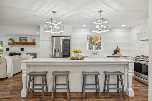 kitchen with a fireplace, appliances with stainless steel finishes, a breakfast bar area, and a large island