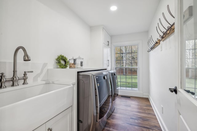 washroom with washer and clothes dryer, dark hardwood / wood-style flooring, cabinets, and sink