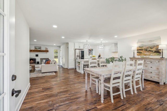 dining area with a fireplace and dark wood-type flooring