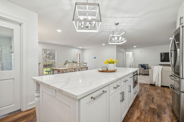 kitchen featuring decorative light fixtures, white cabinetry, dark hardwood / wood-style floors, and stainless steel refrigerator