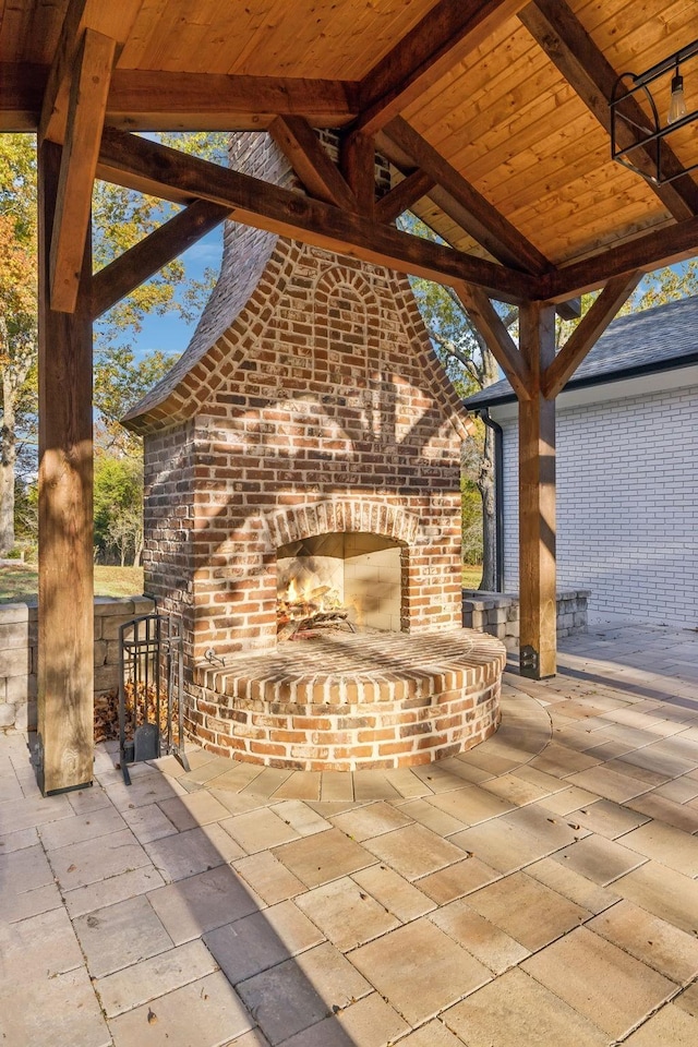 view of patio featuring an outdoor brick fireplace and exterior bar