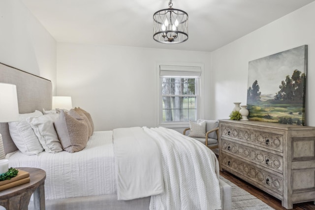 bedroom featuring dark wood-type flooring and a notable chandelier