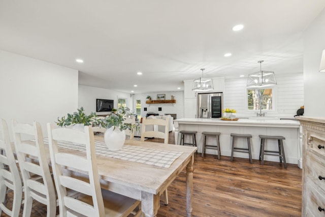 dining area featuring dark hardwood / wood-style floors, sink, and a brick fireplace