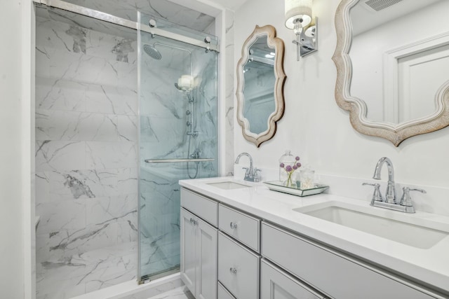 bathroom featuring a shower with door and vanity