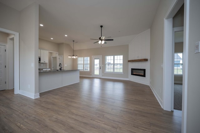 10118 Bighorn Ln, Bell Buckle, TN 37020 - unfurnished living room with a large fireplace, healthy amount of natural light, a ceiling fan, dark wood-style floors, and recessed lighting