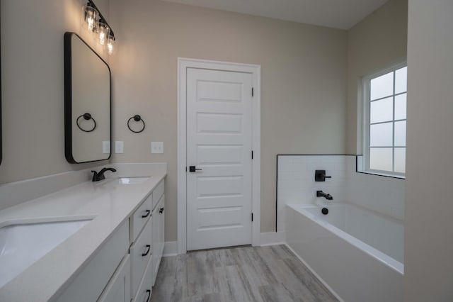 bathroom featuring a bathing tub, vanity, and hardwood / wood-style flooring