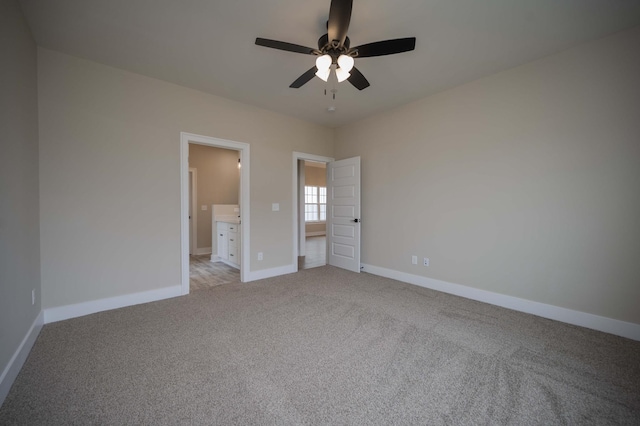 unfurnished bedroom featuring light carpet, connected bathroom, and ceiling fan