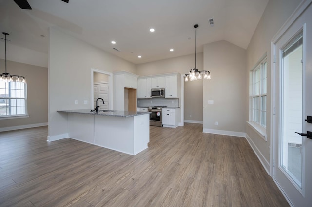 kitchen featuring white cabinets, stainless steel appliances, hanging light fixtures, and sink