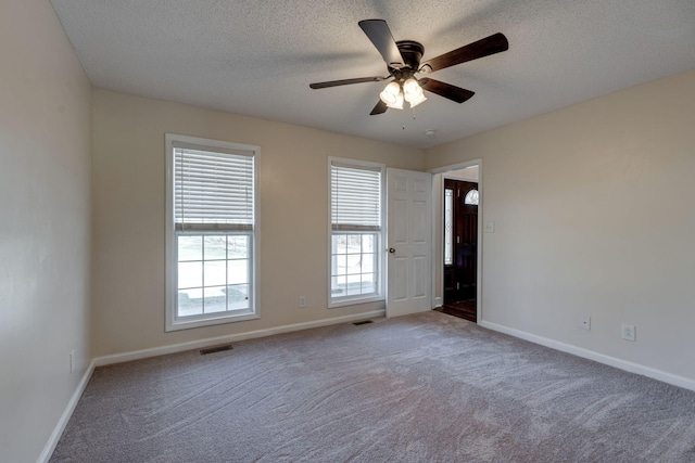 carpeted empty room with a textured ceiling and ceiling fan