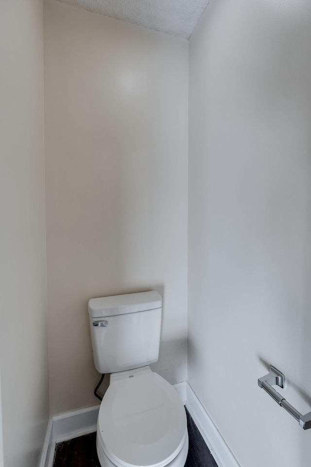 bathroom with toilet and a textured ceiling