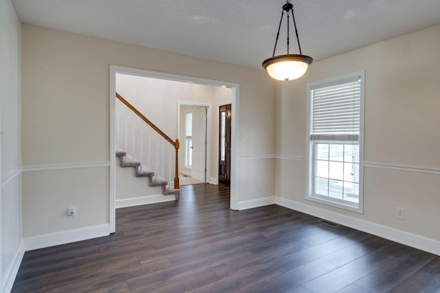 empty room featuring dark hardwood / wood-style flooring and a textured ceiling