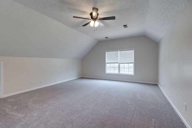 bonus room featuring carpet flooring, ceiling fan, a textured ceiling, and vaulted ceiling