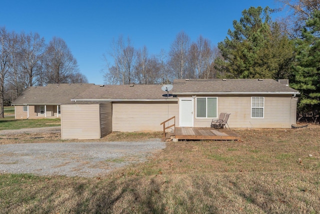 rear view of house with a deck and a lawn