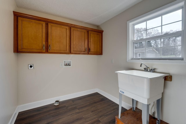 washroom with electric dryer hookup, cabinets, hookup for a washing machine, a textured ceiling, and dark hardwood / wood-style flooring