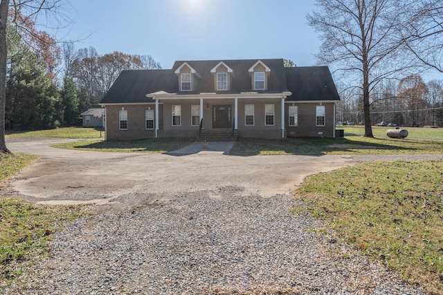 new england style home with a porch and a front yard