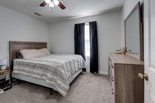 carpeted bedroom with ceiling fan and a textured ceiling