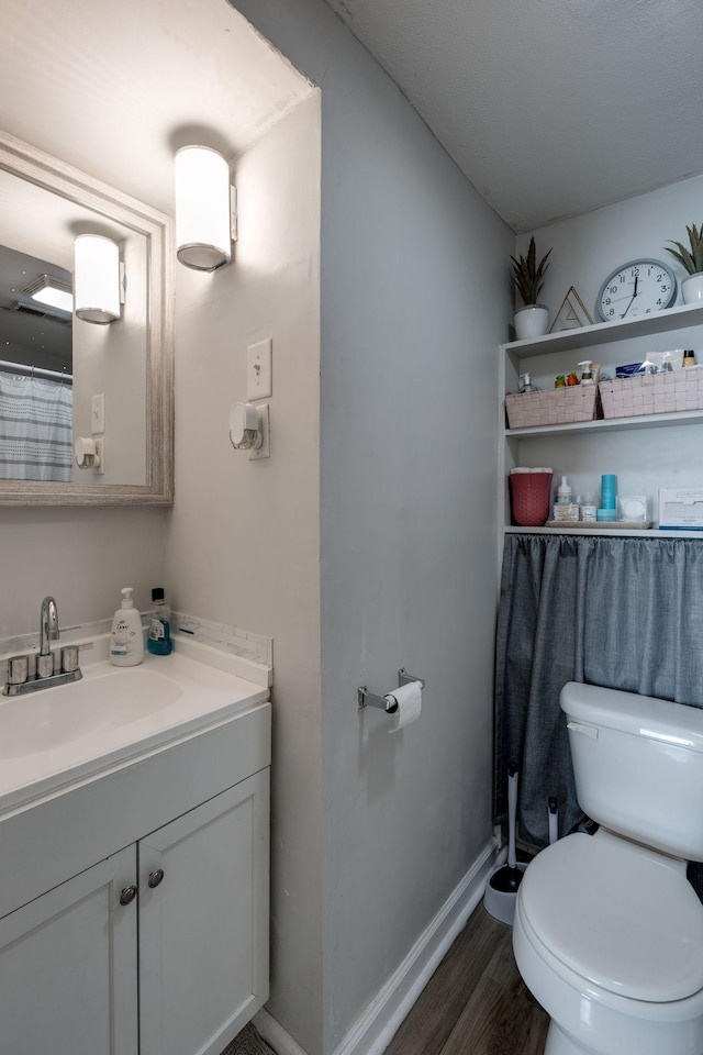 bathroom with vanity, toilet, and wood-type flooring