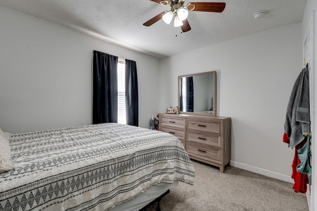 bedroom with a textured ceiling, ceiling fan, and light carpet