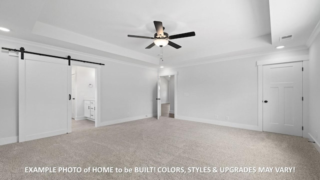 interior space with a tray ceiling, light colored carpet, and a barn door