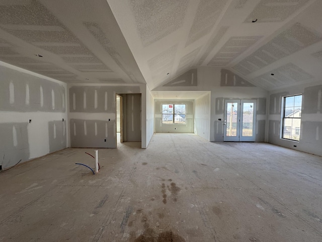 unfurnished living room featuring high vaulted ceiling