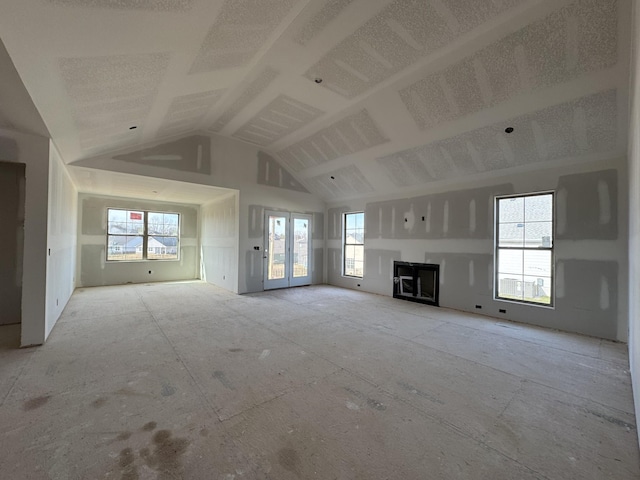 unfurnished living room with plenty of natural light and high vaulted ceiling