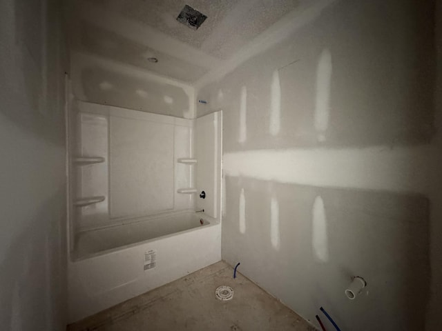 bathroom with tub / shower combination and a textured ceiling