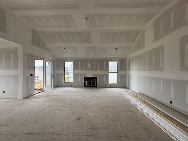 unfurnished living room with high vaulted ceiling