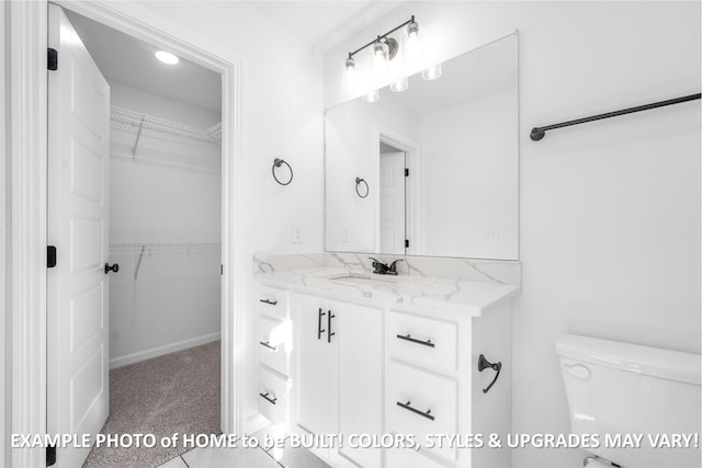 bathroom featuring vanity, a walk in closet, and toilet