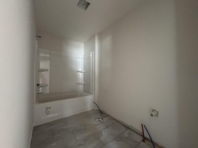 bathroom with marble finish floor and shower / tub combination