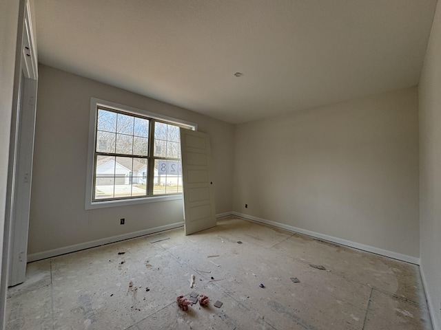 unfurnished room featuring baseboards