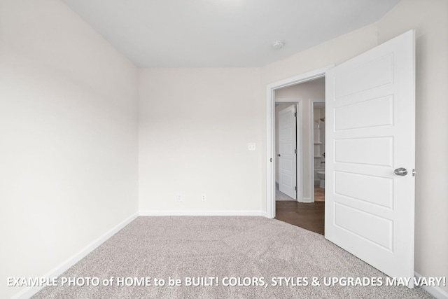 unfurnished room with baseboards and dark carpet