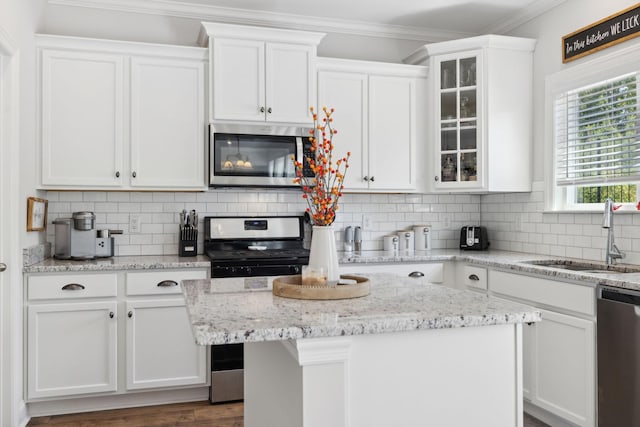 kitchen featuring white cabinetry, sink, a center island, and appliances with stainless steel finishes