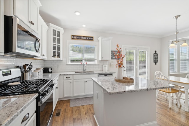 kitchen with a center island, a healthy amount of sunlight, sink, and appliances with stainless steel finishes