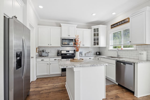 kitchen featuring light stone countertops, appliances with stainless steel finishes, a kitchen island, dark wood-type flooring, and white cabinetry