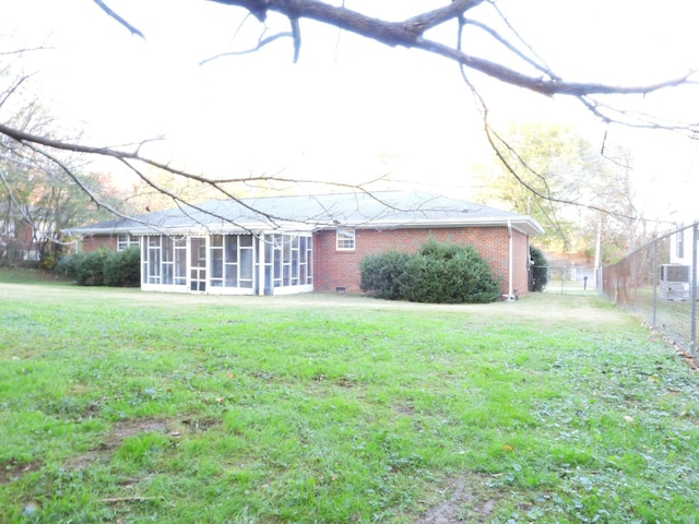 back of property featuring a sunroom and a yard