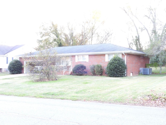 ranch-style home featuring central air condition unit and a front lawn