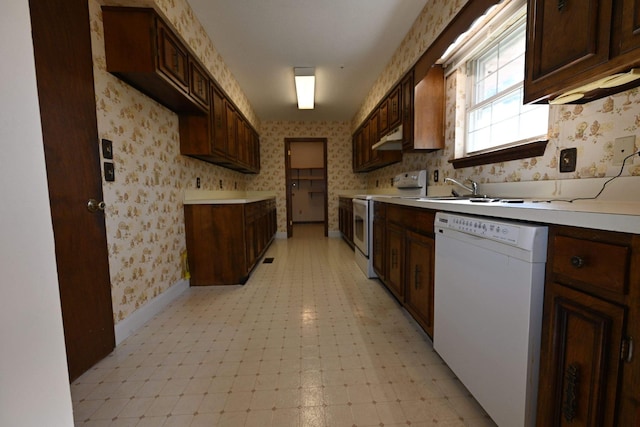 kitchen with dark brown cabinetry, white appliances, and sink