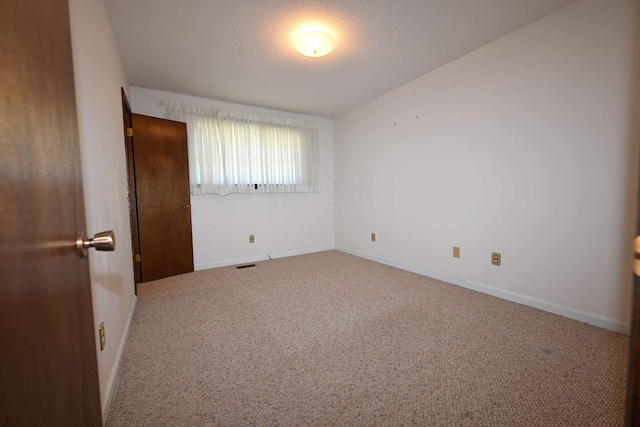 carpeted empty room with vaulted ceiling