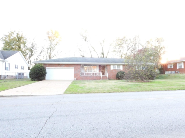 ranch-style home with a porch, a garage, and a front lawn