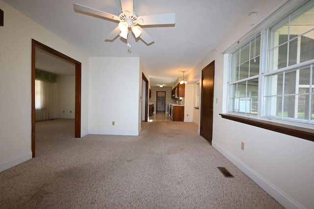 carpeted spare room featuring ceiling fan