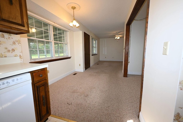 kitchen with dishwasher, ceiling fan, light carpet, and decorative light fixtures