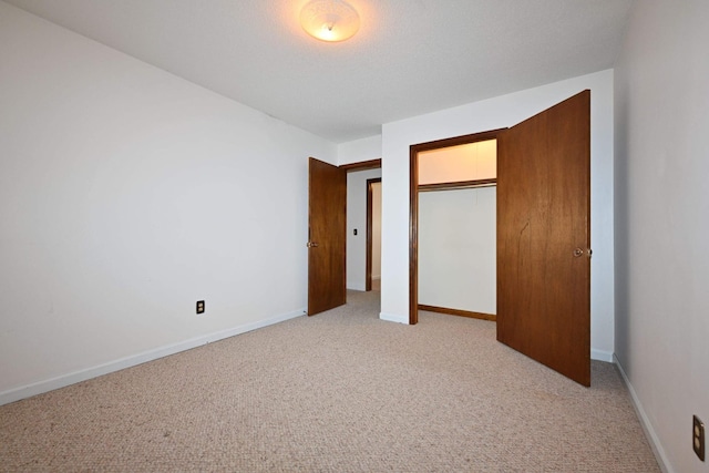 unfurnished bedroom featuring light carpet and a closet