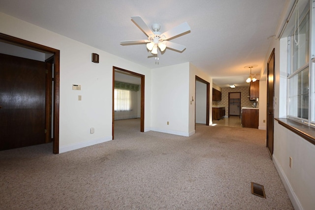 unfurnished living room featuring light colored carpet and ceiling fan