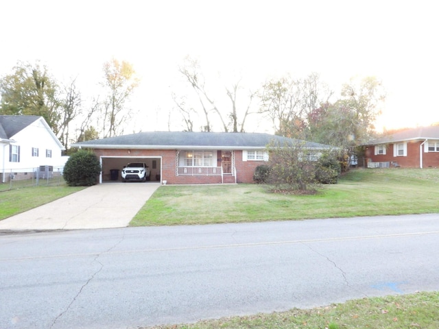 ranch-style home with covered porch, a front yard, and a garage