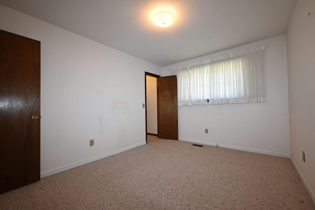 unfurnished room featuring carpet flooring and a textured ceiling