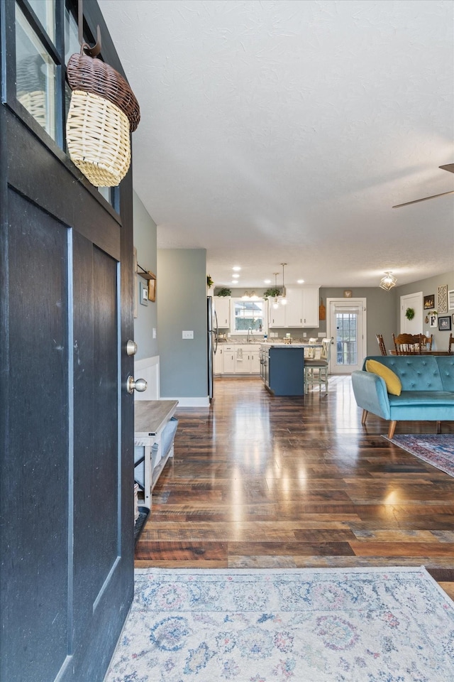 entrance foyer with ceiling fan and dark wood-type flooring