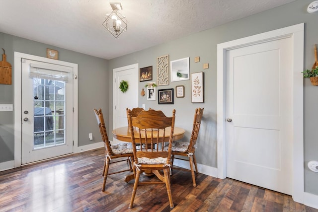 dining space featuring a textured ceiling and dark hardwood / wood-style floors