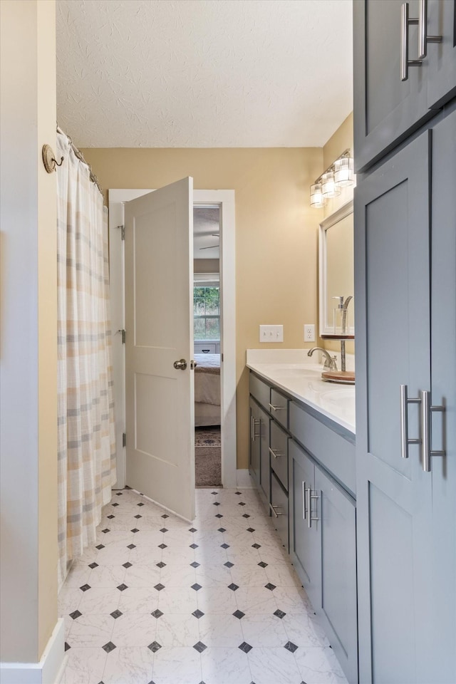 bathroom with vanity, curtained shower, and a textured ceiling