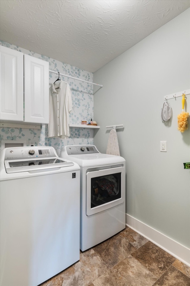 washroom featuring cabinets, independent washer and dryer, and a textured ceiling