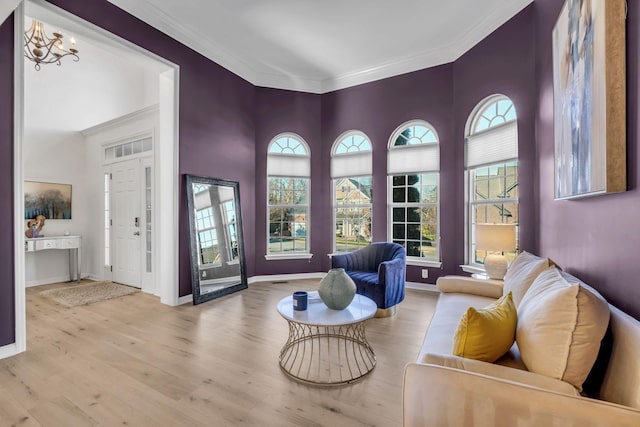 living room featuring ornamental molding, a notable chandelier, and light wood-type flooring